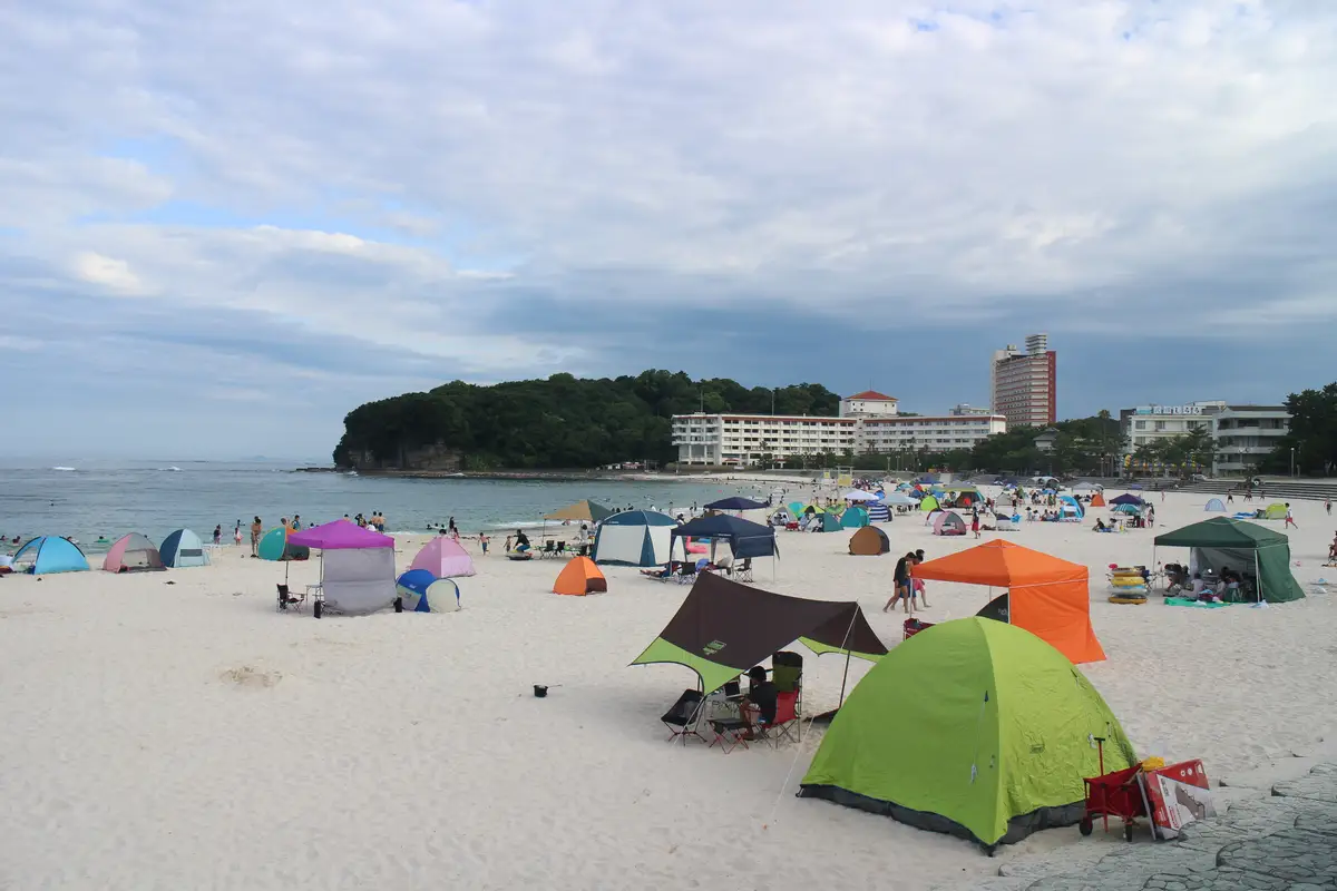 Tents and sunshades crowding the white sand of Shirarahama Beach in late July