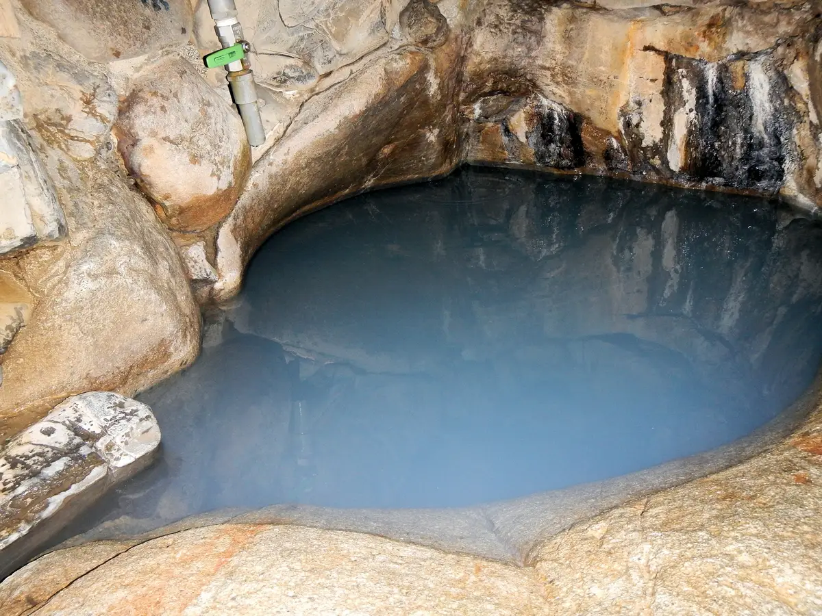 湯峰溫泉壺湯被天然岩石環繞的淡藍色泉水